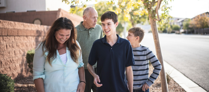 family walking down the street looking happy